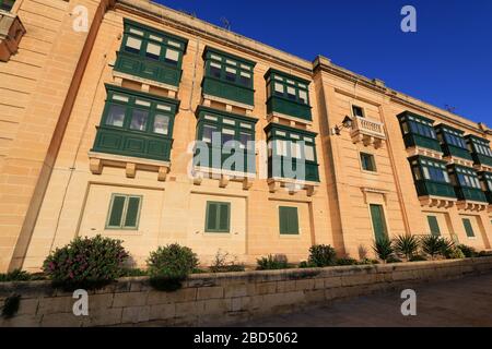 Außenansicht der neu renovierten Wohnhäuser auf der Spitze der Befestigungsanlagen von Valletta, Malta, neben dem berühmten Stadttor Stockfoto