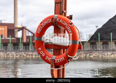 Die Lebensretter der Stadt Helsinki mit dem Kohlekraftwerk Hanasaari und dem Kohlevorrat im Hintergrund im finnischen Merihaka Stockfoto