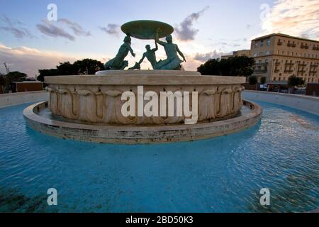 Panoramalicht auf den Tritons-Brunnen (nach der Restaurierung im Jahr 2017) am Rande des Stadttors von Valletta, Malta Stockfoto