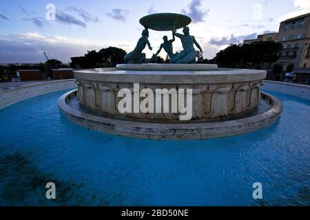 Panoramalicht auf den Tritons-Brunnen (nach der Restaurierung im Jahr 2017) am Rande des Stadttors von Valletta, Malta Stockfoto