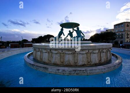 Panoramalicht auf den Tritons-Brunnen (nach der Restaurierung im Jahr 2017) am Rande des Stadttors von Valletta, Malta Stockfoto