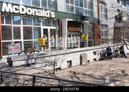 Kiew, Ukraine - 06. April 2020: Kuriere und Lieferdienste Glovo in der Warteschlange bei McDonald's. Die Ukraine hält Bars, Restaurants und Shopping cen Stockfoto