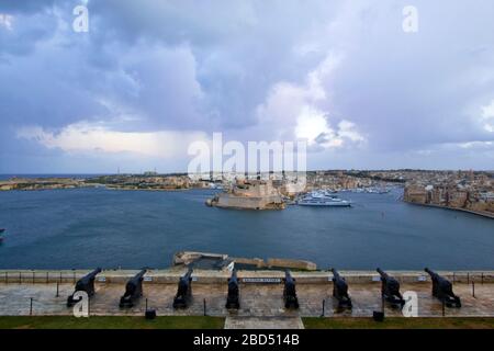 Die Salutierbatterie aus dem 16. Jahrhundert auf der unteren Ebene der St. Peter & Paul Bastion mit Blick auf Fort St. Angelo und den Grand Harbour in Valletta, Malta Stockfoto