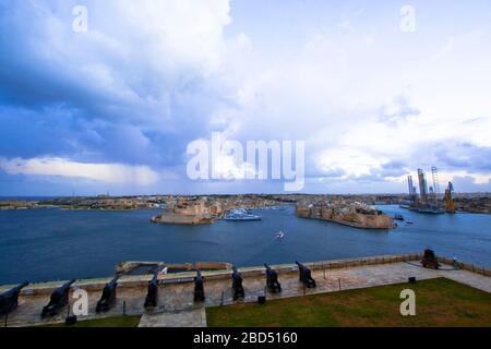 Die Salutierbatterie aus dem 16. Jahrhundert auf der unteren Ebene der St. Peter & Paul Bastion mit Blick auf Fort St. Angelo und den Grand Harbour in Valletta, Malta Stockfoto