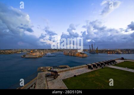 Die Salutierbatterie aus dem 16. Jahrhundert auf der unteren Ebene der St. Peter & Paul Bastion mit Blick auf Fort St. Angelo und den Grand Harbour in Valletta, Malta Stockfoto