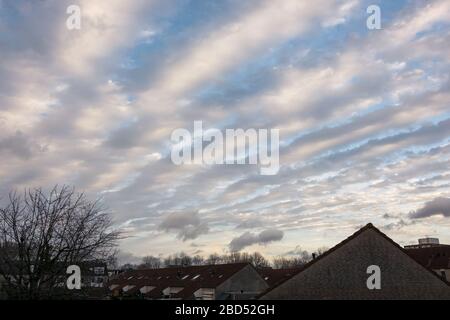 Lange rollende Wolken am Himmel in der Dämmerung, als eine Wetterfront sich nähert. Lateinischer Name der Wolken: Altocumulus undulatus. Stockfoto