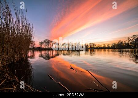 Atemberaubende Farben bei Sonnenuntergang über einem See in den Niederlanden Stockfoto