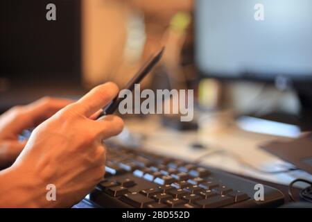 Zeigen Sie den Notebook-Monitor mit digitalem Stift. Arbeiten Sie mit Konzentration. Tippen Sie mit der Hand auf das Nummernfeld der Tastatur, während Sie die Maus auf der Lasche ruhen lassen Stockfoto