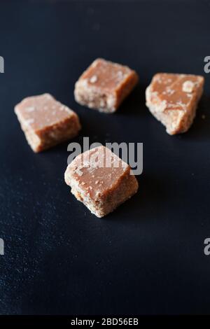 Vier Fudge-Stücke von oben auf schwarzem Hintergrund geschossen Stockfoto