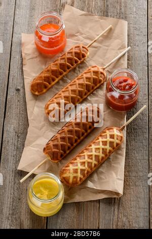 Draufsicht auf Waffelkornhunde, serviert mit Ketchup, Senf und BBQ-Sauce Stockfoto