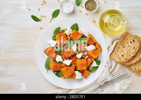 Salat mit geröstetem Kürbis, Fetakäse, Spinat, Nüssen mit Honig und Gewürzen, Draufsicht Stockfoto