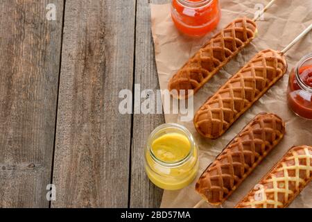 Maishunde werden mit Gläsern verschiedener Soßen serviert Stockfoto