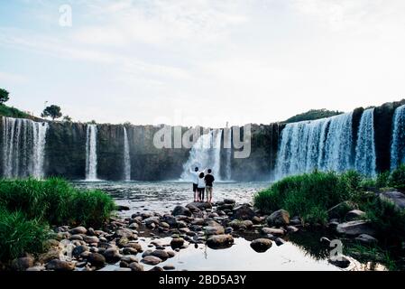 Drei Freunde stehen am Fuße des Harajiri-Wasserfalls in Oita, Japan. Stockfoto