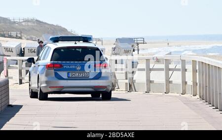 Westerland, Deutschland. April 2020. Ein Polizeiwagen fährt entlang der Promenade. Für die Nordseeinsel gelten derzeit spezielle Zugangsregelungen. Credit: Carsten Rehder / dpa / Alamy Live News Stockfoto