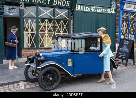 Eine verkleidete Dame, die am Wochenende der 40er Jahre im Black Country Living Museum in Dudley, West Midlands, England, Großbritannien, in ein Oldtimer einzieht Stockfoto