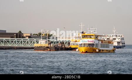 Ein Gelbes Boot-Tour-Schiff, das von seinem Dock in Terreiro do Paco am Ufer des Flusses Tejo, Lissabon, Portugal abfährt. Stockfoto