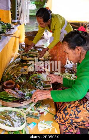 Vertikaler Blick auf Damen, die in einem Tempel in Bali, Indonesien Dekorationen zu bieten haben. Stockfoto