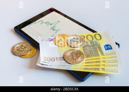 Wachsende Grafik auf dem Smartphone-Bildschirm mit Bitcoin- und Papierwährung Euro Coins. Stockfoto