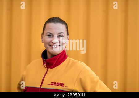 Gelsenkirchen, Deutschland. April 2020. Paketzustellerin Yvonne Kumpf steht vor einem DHL-Logistikzentrum in Gelsenkirchen. Sie ist eine der "Helden der Corona-Krise" und arbeitet in einem systemwichtigen Beruf. Kredit: Fabian Strauch / dpa / Alamy Live News Stockfoto