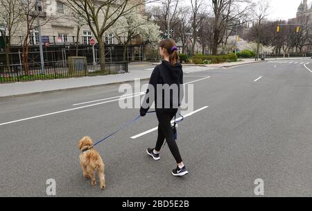 Manhattan, New York, USA, 2020. Ein junges Mädchen, das ihren Hund während des Coronavirus Lockdowns über eine leere Autobahn in Manhattan spazieren ließ. Stockfoto