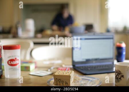 Mutter bereitet und kocht Familienessen in der Küche während der Arbeit von zu Hause während der Selbstisolation - 2020 COVID-19 Coronavirus Pandemie Stockfoto