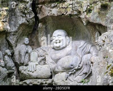 Lachender Buddha Maitreya und Schüler Steinschnitt Skulptur, Felai Feng Grotten, Lingyin Tempel, West Lake, Hangzhou, Chins Stockfoto