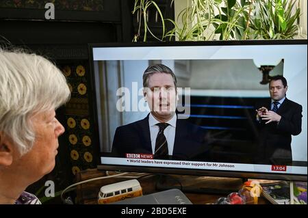 Ältere Frau, die einen Nachrichtenbericht mit Keir Starmer, dem Führer der Labour-Partei, beobachtet, der über die Antwort der Regierung auf Covid-19 spricht Stockfoto