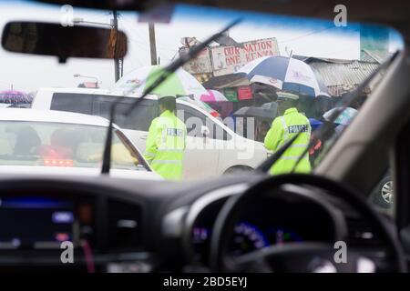 Die Polizei, die den Verkehr während der Hauptverkehrszeit am Morgen, während eines Regensturms, in Nairobi, Kenia, Kenia, zusammen mit anderen Ländern in E.Afrika lenkt, hat h Stockfoto