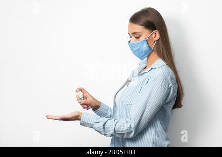 Frau In Maske Mit Medizinischem Desinfektionsspray Über Weißem Hintergrund Stockfoto