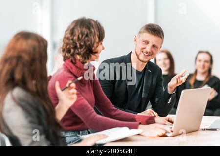 Gruppe junger Mitarbeiter, die am Büroschalter sitzen Stockfoto