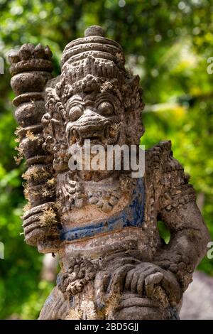 Vertikale Nahaufnahme einer Schutzstatue am Tor, die einen Tempel in Bali, Indonesien schmückt. Stockfoto