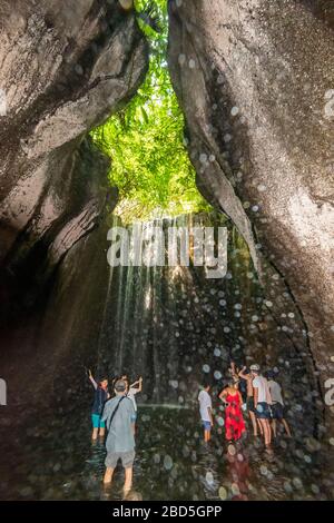 Vertikaler Blick auf die Touristen an den Tukad Cepung-Wasserfällen in Bali, Indonesien. Stockfoto