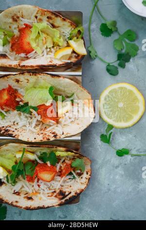 Hausgemachtes Huhn Tikka Tacos serviert auf einem Taco-Metallständer, selektiv fokussiert Stockfoto