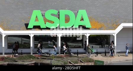 Brighton, Großbritannien. April 2020. Kunden nehmen soziale Distanzierungen vor, während sie vor einem Asda-Supermarkt in Brighton Marina Schlange stehen. Credit: James Boardman/Alamy Live News Stockfoto