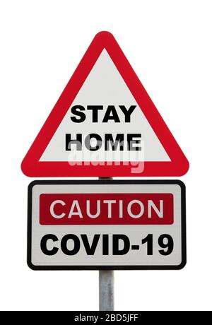 Dreieckschild Warnung Achtung COVID-19 mit den Worten BLEIBEN ZU HAUSE Nachricht, um neue Coronavirus Lockdown Regeln Konzept zu veranschaulichen. Wales Stockfoto