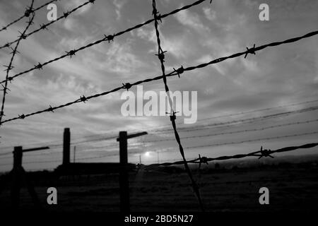 Der Barb-Drahtzaun liegt am grauen, düsteren Himmel. Dies ist Majdanek oder KL Lublin - ein nationalsozialistisches Konzentrations- und Vernichtungslager, das errichtet wird Stockfoto