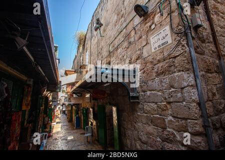 Geschäfte und Verkaufsstände in einer Gasse in der Altstadt, Jerusalem, Israel Street Schild auf Englisch Hebräisch und Arabisch Stockfoto