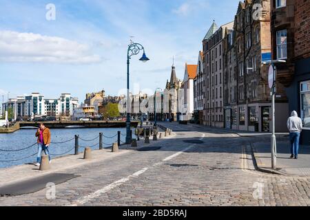 Leith, Edinburgh, Schottland, Großbritannien. April 2020. In der dritten Woche des landesweiten Coronavirus Sperrlebens in Leith geht es weiter, obwohl die Straßen meist verlassen sind und Geschäfte geschlossen sind. Abgebildet; normalerweise beschäftigt, ist das Ufer in Leith fast leer. Stockfoto