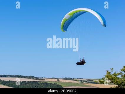 Millington, East Yorkshire, Großbritannien, 09/06/2015 - ein einzelner Gleitschirm, der über Hügel und Ackerland mit einem klaren blauen Hintergrund schwimmt. Stockfoto