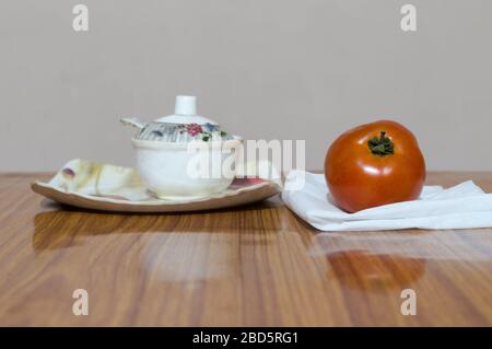 Tomaten und Untertasse auf Holztisch. Tomatensauce (neapolitanische Soße, Salsa roja auf Spanisch oder Salsa di pomodoro auf Italienisch) Stockfoto