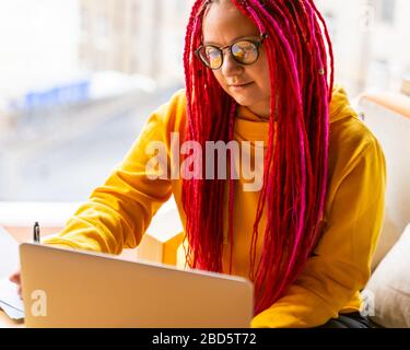 Digitales Nomadenkonzept. Freiberuflicher Girl-Mitarbeiter, der im Café mit Laptop arbeitet. Stockfoto
