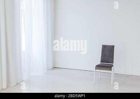 Grauer Vintage-Stuhl im Inneren eines leeren weißen Raumes Stockfoto