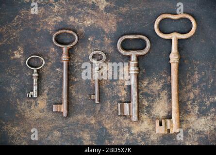 Escape Zimmer Konzept, Gruppe von antiken Schlüsseln auf rostigen Metall Hintergrund Stockfoto