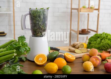 Gesundes Frühstück mit grünem Smoothie im Mixer und frischen Zutaten Stockfoto