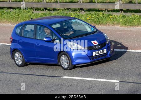 2011 Blue Honda Jazz i-VTEC es; Fahrschüler Autobahntraining, unter Anleitung, Fahrschule, Fahrer, Autobahnfahrunterricht, Zugelassener Fahrlehrer, beaufsichtigter Fahrlehrer, Fahrlehrer; Kfz-L-Kennzeichen auf sich bewegenden Fahrzeugen, Fahren von Fahrzeugen auf britischen Straßen, Motoren, Fahren auf der Autobahn M6 Stockfoto