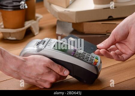 Mann, der mit Karte für Kaffee und Pizza bezahlt Stockfoto