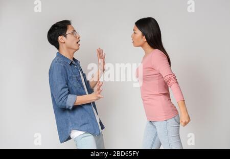 Verrücktes asiatisches Mädchen will seinen Freund schlagen Stockfoto
