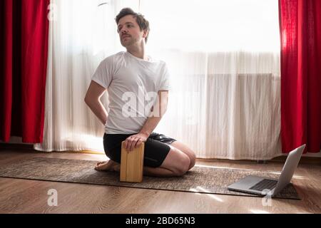 Porträt eines gesunden jungen Mannes, der Yoga macht Spine verdrehen Pose Stockfoto
