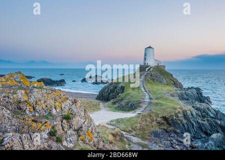 Sonnenuntergang am frühen Abend, Leuchtturm TWR Mawr auf der Gezeiteninsel Llanddwyn Island, Anglesey, Nordwales Großbritannien, Blick über die Menai Strait Meer. Stockfoto