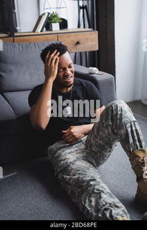 Weinender afroamerikanischer Soldat mit Armeeausweis, der zu Hause unter PTSD leidet Stockfoto